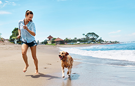 Summer Beach Fun. Woman Running With Dog. Holidays Vacations